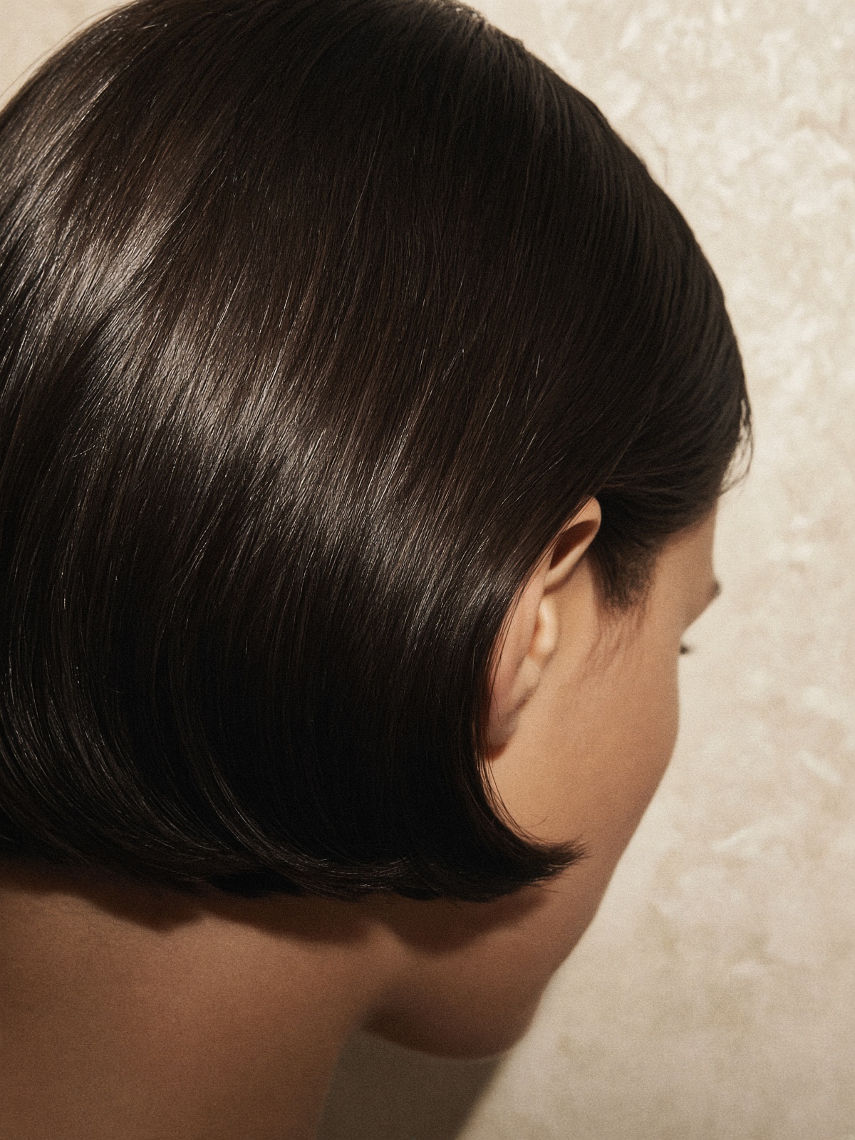A precise dark brunette bob with a clean, glossy line